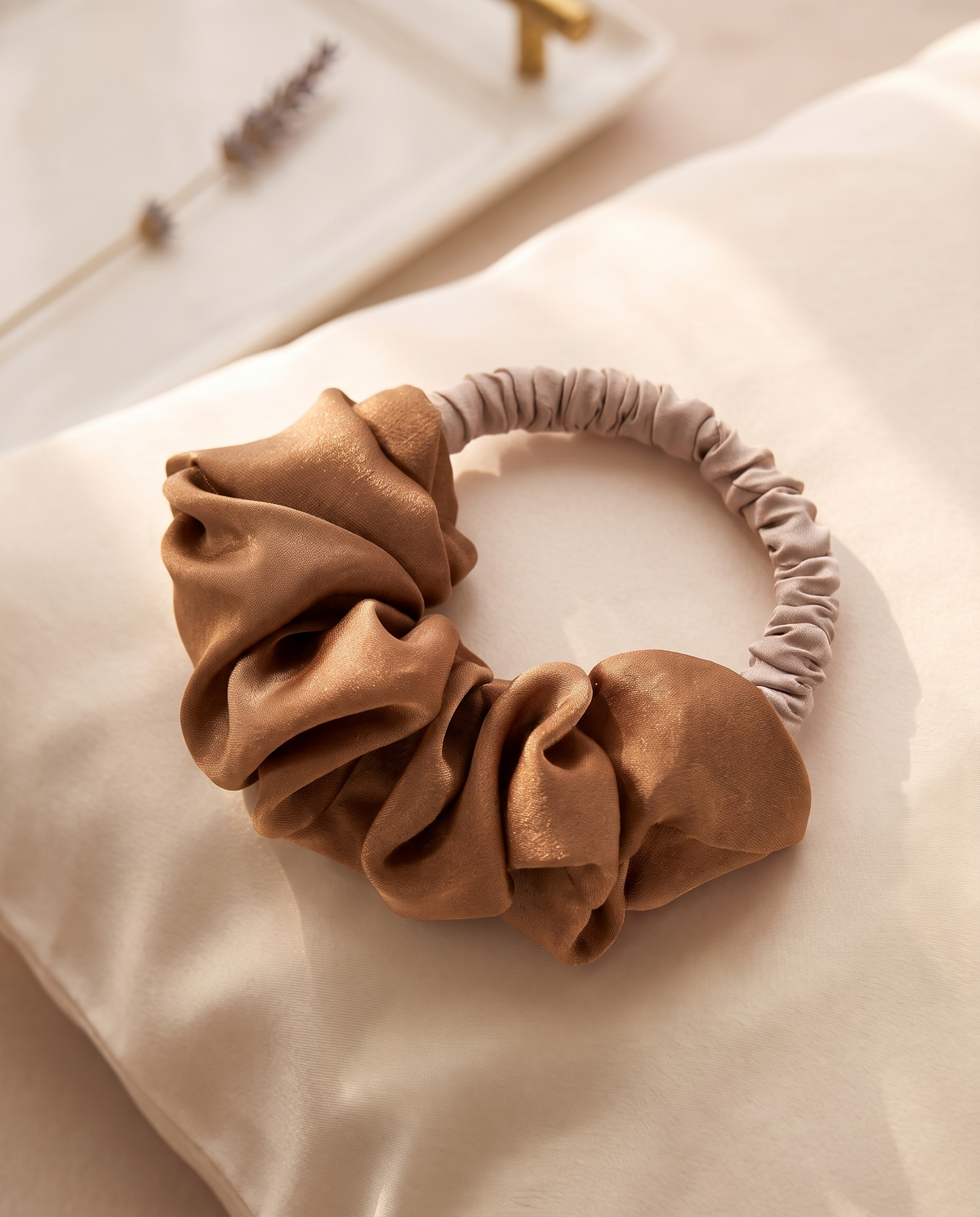 Latte heatless curl scrunchie on a cream silk pillowcase