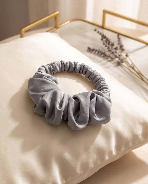 Silver heatless curl scrunchie on a cream silk pillowcase